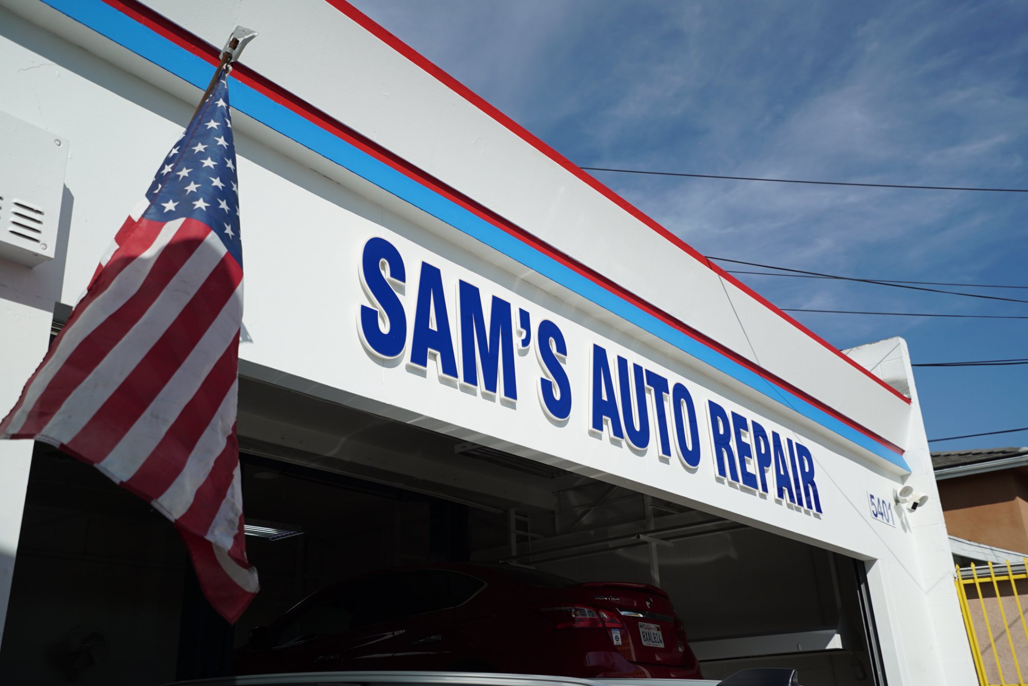 Sam's Auto Repair shop front close-up — signage and American flag at 5401 York Blvd Eagle Rock
